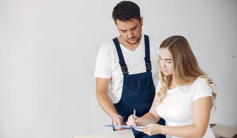 A mover signing paperwork with a customer.