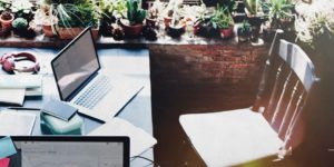 Laptop on the table and an empty chair - learn who your customers are and what they need from you.