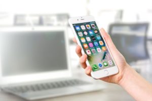 Woman holding a smartphone - examine the software investment trends that can help you develop your company.