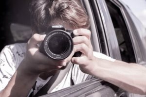 Man holding a camera pointed at you - present your company to people visually.