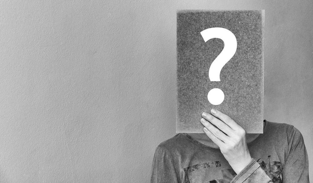 Person holding a notebook with question mark on it