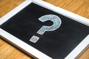a white question mark on the black board
