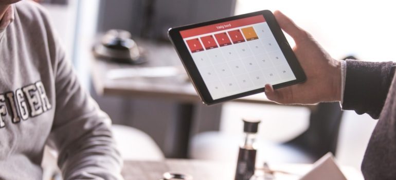 Person holding an iPad with a calendar