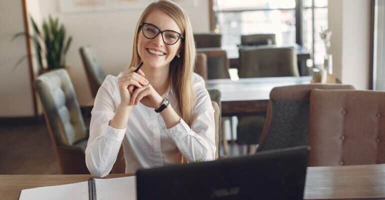 Woman sitting behind a laptop, smiling