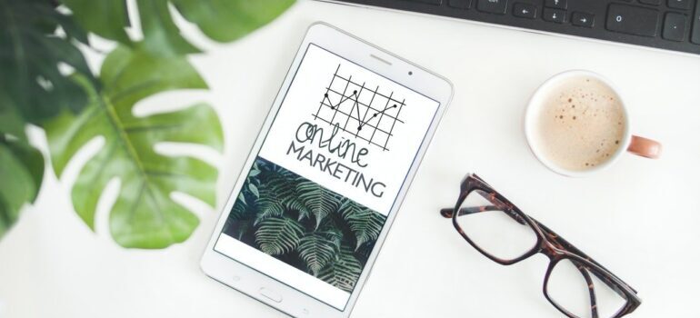 Tablet with Online Marketing tag on it, next to pair of glasses and a keyboard.