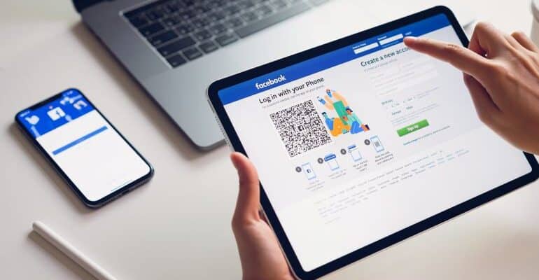 Hand pressing the FB login button on iPad