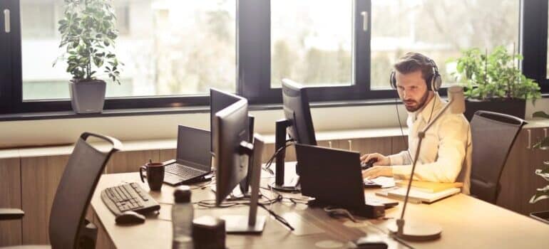 A man using the benefits of field service management software on a computer.