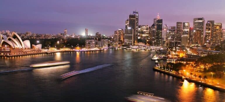 A view of Sydney Bay at night with ships on the water.