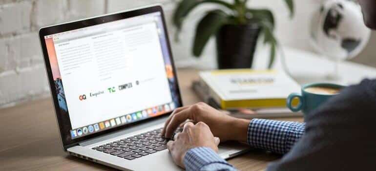 Person using a laptop to write guest blog articles.