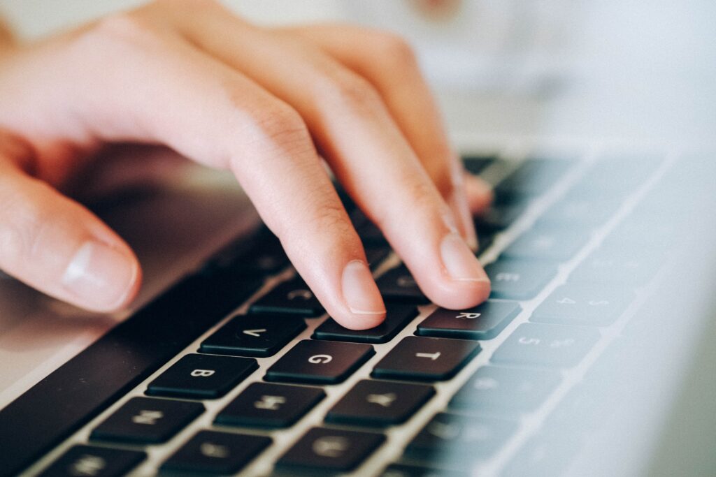 A hand typing on a keyboard