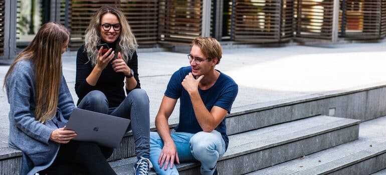 Young people in front of a library, talking about Snapchat marketing tips for businesses.