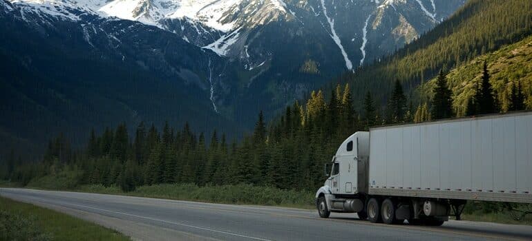 Moving truck driving down a road.