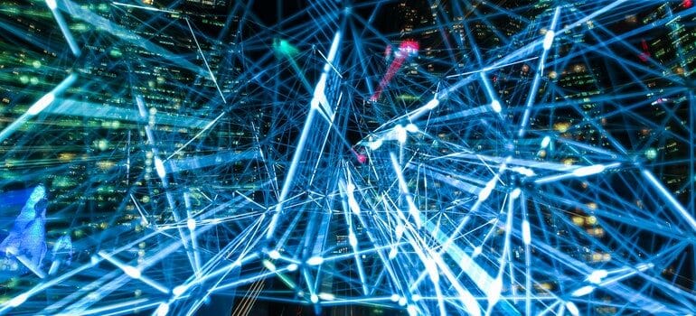 Photo of a city at night overlaid with neon blue lines.