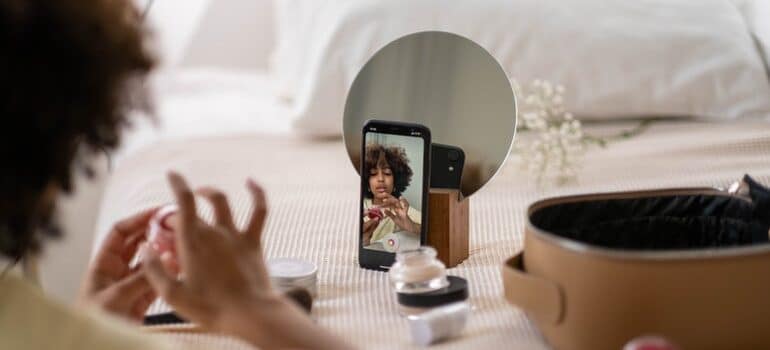 Person filming themselves putting on makeup.