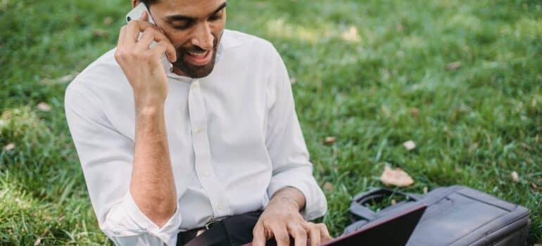 a man using a phone and a laptop