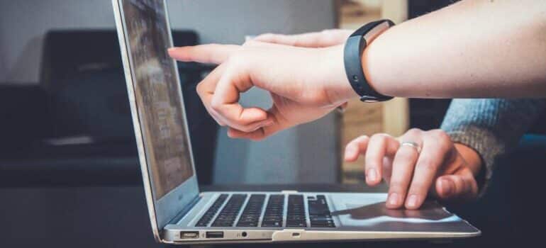 person pointing at a computer screen