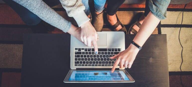 People pointing at a laptop screen