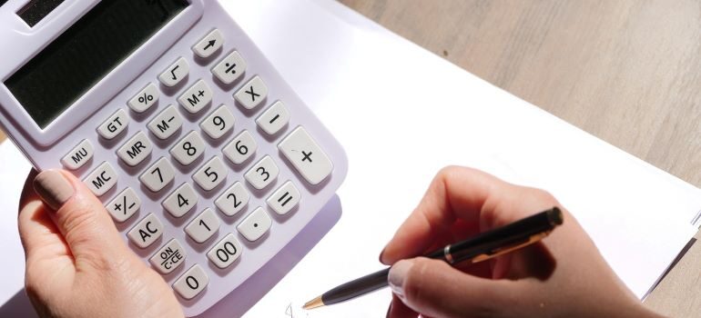 Person doing a pricing estimate with a piece of paper and calculator.