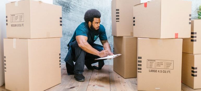 A man carrying a box and thinking about