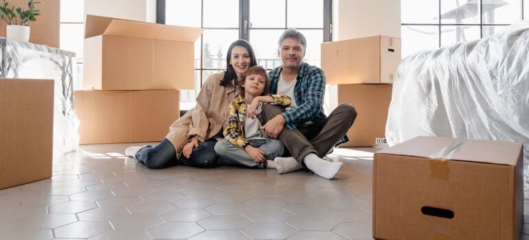 Family surrounded by packed cardboard boxes.