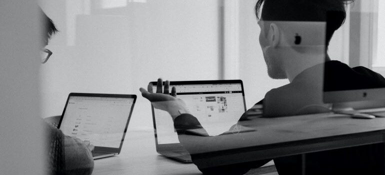 Two people using MacBooks.