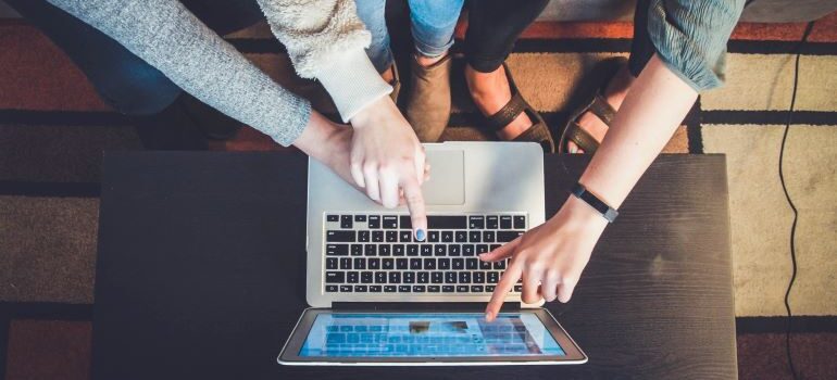 Three persons on a laptop.