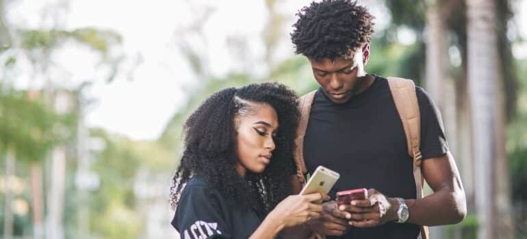 Two people looking at their phones.