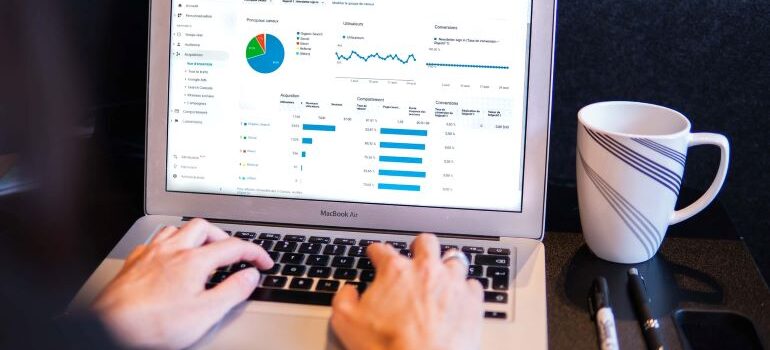 Person looking at graphs and analytics on laptop screen.