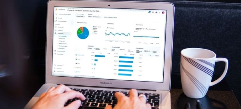 A person going thorough Google analytics on their laptop