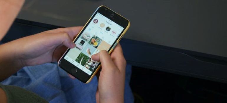 Person holding a phone with Instagram profile opened on it