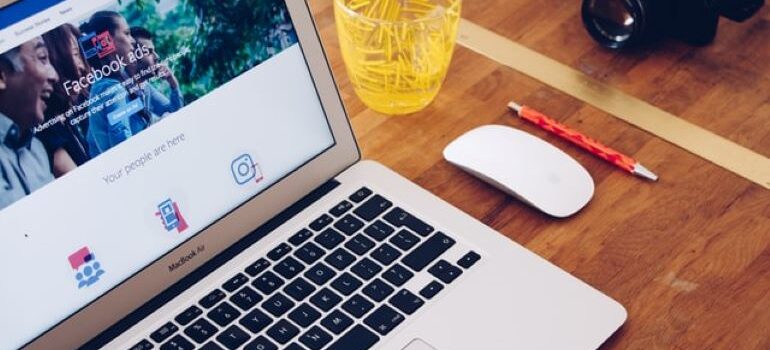 Professional camera next to a laptop with Facebook ad page opened on it