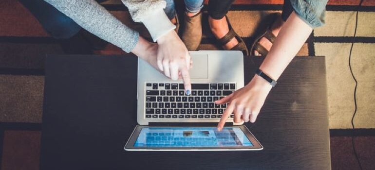 Three people sitting on a couch and looking at a laptop, searching for lead engagement software solutions