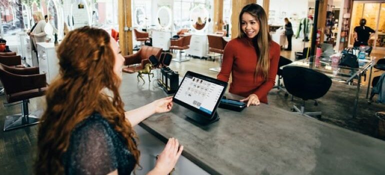 Two women sitting at a desk across each other and discussing lead engagement software solutions