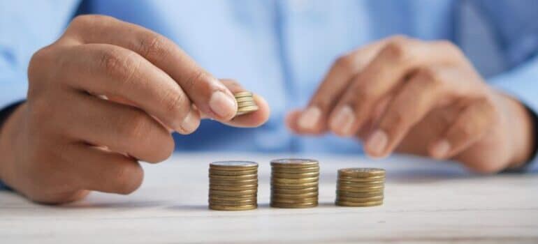 A person stacking coins on a table.