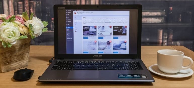 Laptop with WordPress admin page opened on it on a wooden desk with a bookshelf in the background