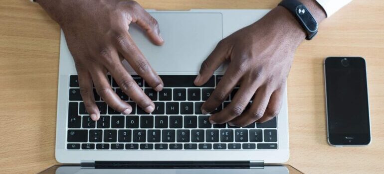 A man is typing an email on his laptop.