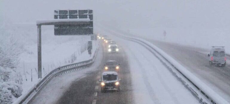 Cars drive in poor weather.