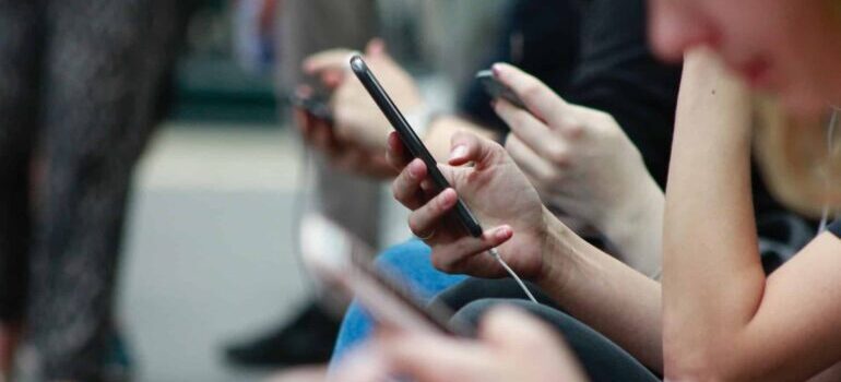 People on their phones sitting next to each other.