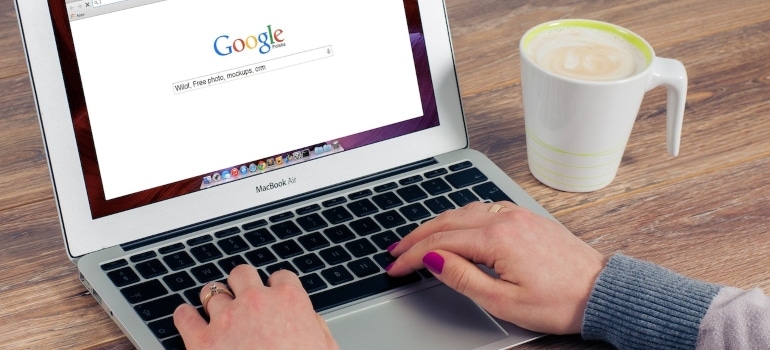 Person searching for local moving company on Google using a MacBook