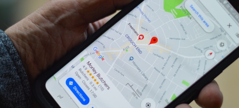 Person holding a phone with a Google My Business listing opened on it