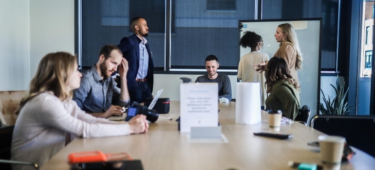 Group of people sitting at the desk and trying to avoid fraudulent digital marketing agencies