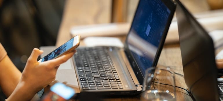 A person using a phone and a laptop and reading about using landing pages for lead generation