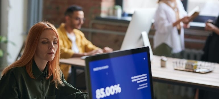 People in an office working and using laptop