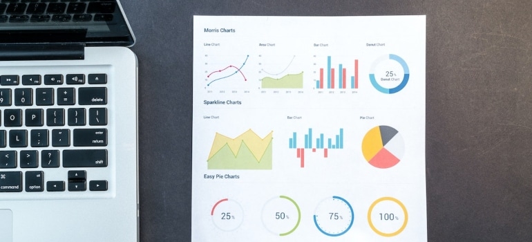 Analyzing data on a paper next to a laptop