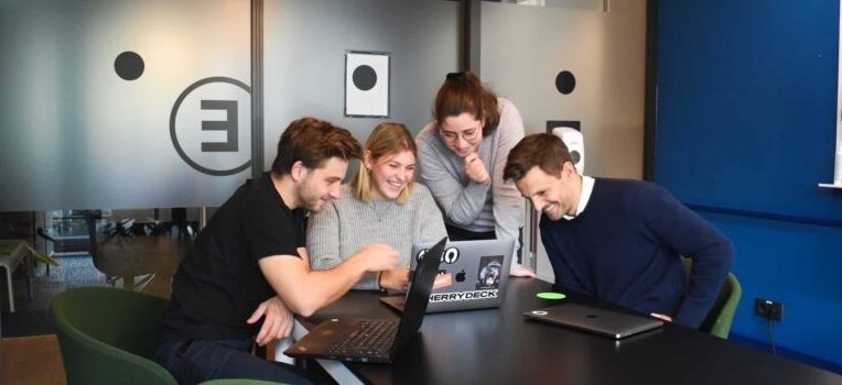 Group of people researching the benefits of referral marketing in a meeting room