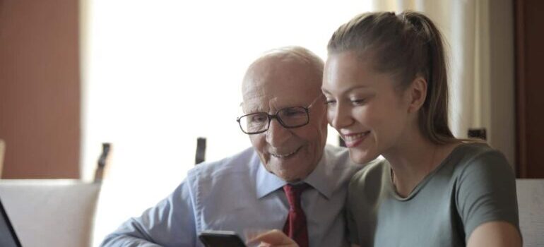 Granddaughter showing her grandfather how to book movers on her smartphone