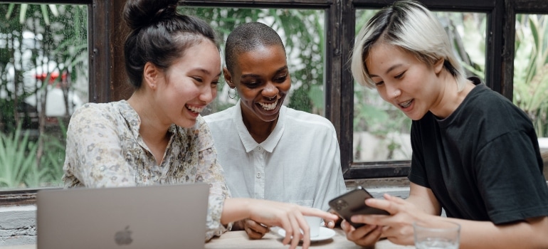 three people looking at a mobile phone