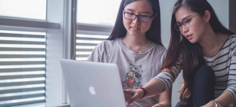 Two women researching how to leverage local SEO for your storage facility on a laptop