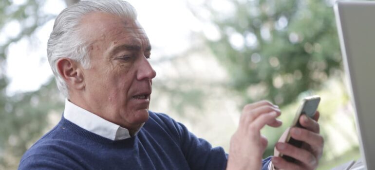 elderly man looking at his phone