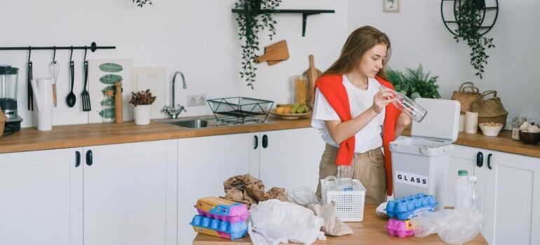 Person separating trash for recycling in their kitchen